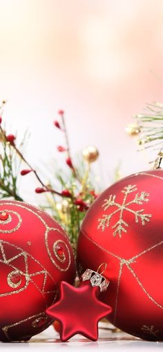 two red christmas ornaments sitting next to each other