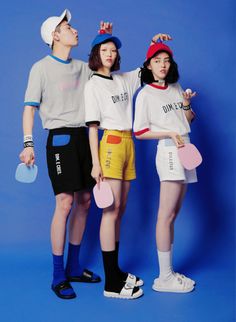 three people standing next to each other holding ping pong paddles