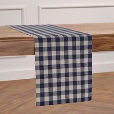 a blue and white checkered table runner sitting on top of a wooden bench