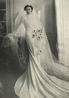 an old photo of a woman in a wedding dress with veil and flowers on it