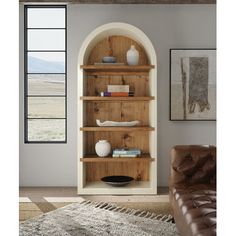 a living room with a brown leather chair and book shelf in the middle of it