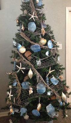 a christmas tree decorated with seashells and starfish