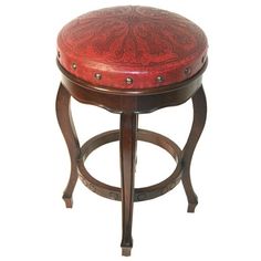 a red stool with an ornate design on it's back and footrests