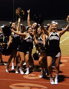 a group of cheerleaders standing on a field