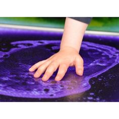 a person's hand on top of a purple object