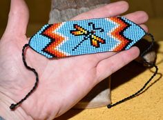 a hand holding a beaded object in it's palm