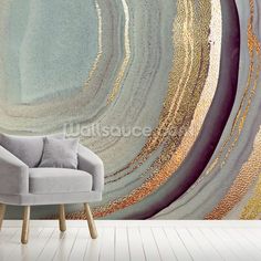 a chair sitting in front of a wall with an abstract painting on it's side