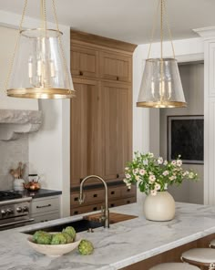 a kitchen with two hanging lights over the island