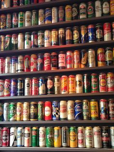 an assortment of beer cans on shelves in a store