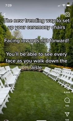 a row of white chairs sitting on top of a lush green field