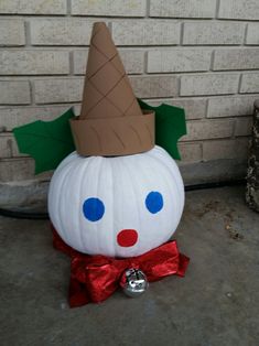 a pumpkin with a hat on it sitting in front of a brick wall