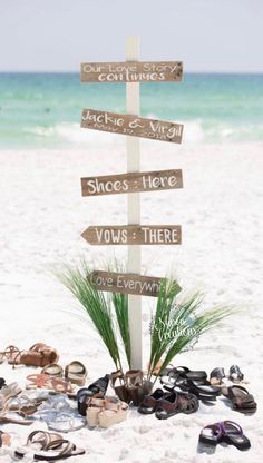 a sign that is on the sand with shoes in front of it and an arrow pointing to different destinations