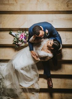 the bride and groom are posing for a photo on the stairs at their wedding reception