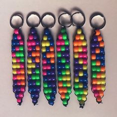 six key chains with different colored beads hanging from each one's sides, all lined up in a row