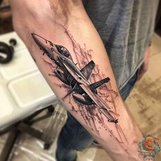 a man with a tattoo on his arm that has an airplane in the middle of it