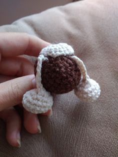 someone is holding a small crocheted stuffed animal