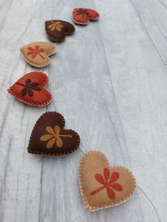 five hearts are lined up on a white surface with red, brown and orange designs