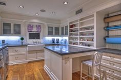 a large kitchen with white cabinets and blue counter tops