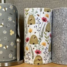 three rolls of toilet paper sitting next to each other on a wooden table with a metal holder