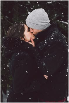 a man and woman kissing in the snow