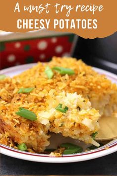 a white plate topped with cheesy potatoes covered in grated cheese and green onions