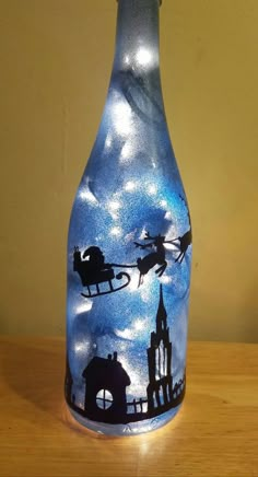 a glass bottle that is sitting on a wooden table with a sky scene painted on it