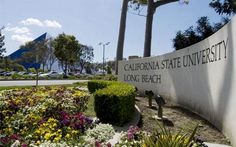 the california state university sign is surrounded by colorful flowers and trees in front of it