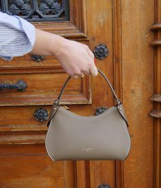 Prestigious and modern, our taupe Mini Pivoine handbag embodies timelessness with elegance.
Handcrafted in our Italian workshop, this bag is designed from the highest quality grained calf leather, adorned with meticulous golden finishes. Versatile, it can be carried by hand, on the shoulder, or crossbody thanks to its additional strap. Its solid zipper reveals a beige interior, ensuring a safe and organized space for your essentials. Classic Bags Timeless, Taupe Bag, Timeless Bags, Beige Interior, Timeless Chic, Elegant Bags, Purse Brands, Scarf Headband, Metal Accessories