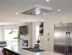 a modern kitchen with stainless steel appliances and white countertops, along with an island in the middle