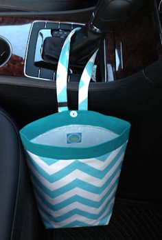 a blue and white bag sitting on top of a car seat next to a steering wheel