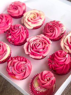 a box filled with pink cupcakes covered in frosting