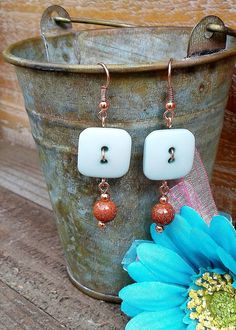 a pair of earrings sitting on top of a bucket