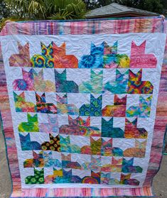 a colorful quilt is hanging on a pole