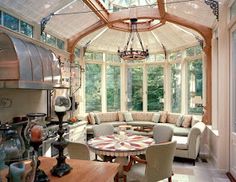 a living room filled with furniture and a large window covered in glass roof over it