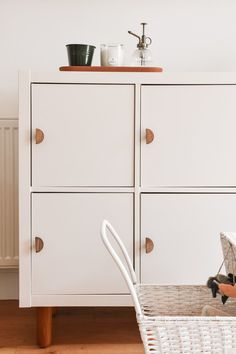 a white dresser with two drawers and a baby in a stroller next to it