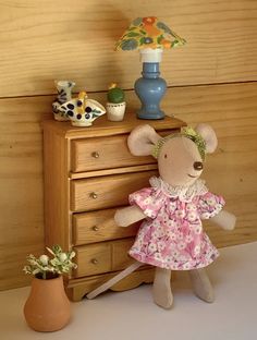 a stuffed mouse is standing next to a dresser