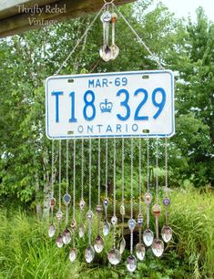 a license plate hanging from the side of a wooden structure with lots of spoons attached to it