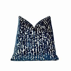 a blue and white pillow on a white background