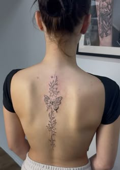 a woman with a butterfly tattoo on her back