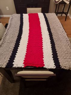 a bed with a red, white and blue blanket on it