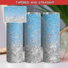 three blue and silver tumbles with snow flakes on them, one is empty