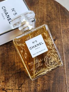 a bottle of chanel no 3 perfume sitting on top of a wooden table next to a box