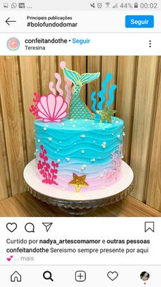 a blue and pink cake sitting on top of a table next to a wooden wall