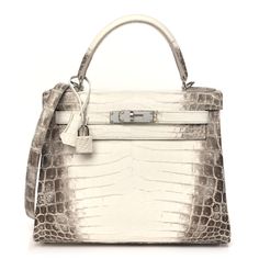 This authentic HERMES Matte Niloticus Crocodile Himalaya Kelly 28 in Blanc is a masterpiece. Equally iconic and elusive, the Himalaya Kelly is an exquisite piece of fashion art history. Created from a backdrop of freshwater niloticus crocodile skin, this rare Kelly bag has been expertly tanned and dyed to attain beautiful contrast shading. Hand-sewn stitching has been applied by a technique passed down through the centuries to an expert Hermes craftsman. Palladium plated hardware with protective Hermes Kelly Himalayan, Hermes Kelly Crocodile, Hermes Kelly Bag Crocodile, Hermes Mini Kelly Crocodile, Hermes Crocodile Bag, Hermes Black Small With Shiny Cocrodile, Crocodile Bags, Crocodile Skin, Kelly Bag