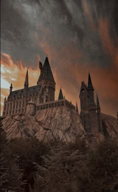 the hogwarts castle at sunset with dark clouds