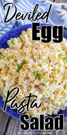 a blue bowl filled with pasta salad on top of a wooden table and the words deviled egg pasta