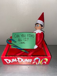 an elf is holding a sign in a box