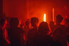 a group of people standing in front of a red light at an event or party