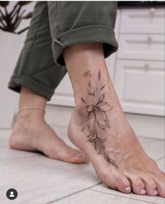 a woman's foot with a flower tattoo on her left ankle and the bottom part of her leg