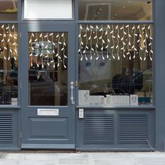 the front door of a store with decorative glass on it's windows and doors